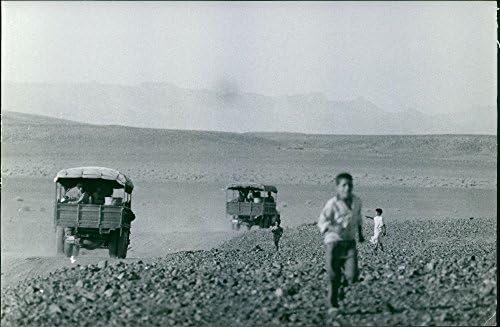 Vintage fotó, Gyermek fut mögötte pedig egy mozgó teherautó Algériában